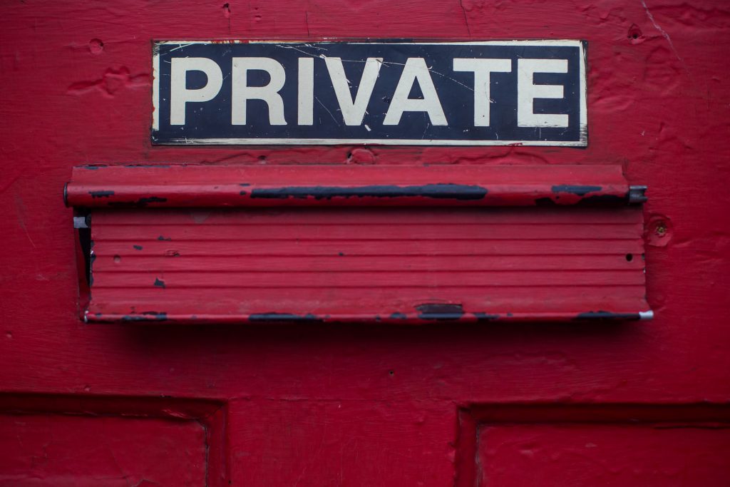 Picture of a mail slot in a door with the words private above it.